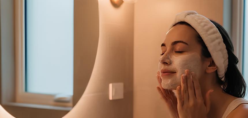 A woman cleaning her face in the bathroom getting ready for sleep